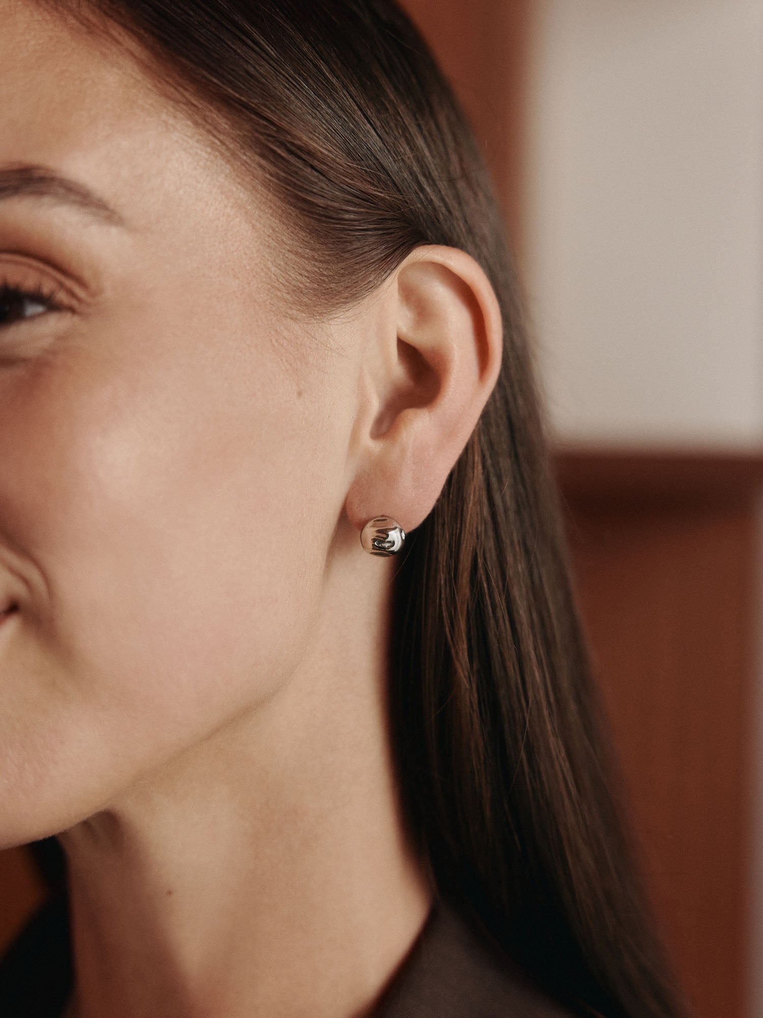 Roségoldene Creolen mit elegantem Design, getragen von einer Frau, PURELEI.