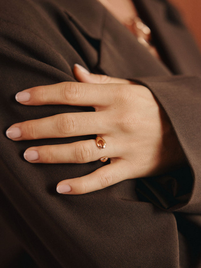 Eleganter Ring aus Roségold mit funkelndem Stein, getragen auf einem Handgelenk, PURELEI.