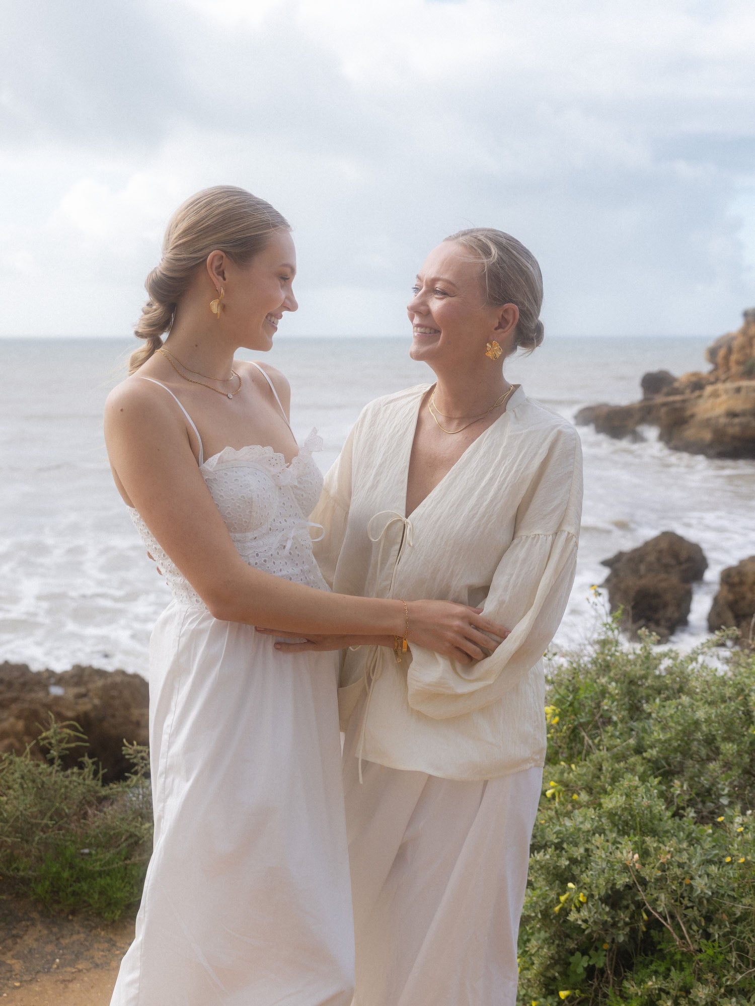 Flora Ohrringe in 18K Gold mit abstrakter Blütenform, getragen am Meer, PURELEI-Eleganz und femininem Island-Spirit.