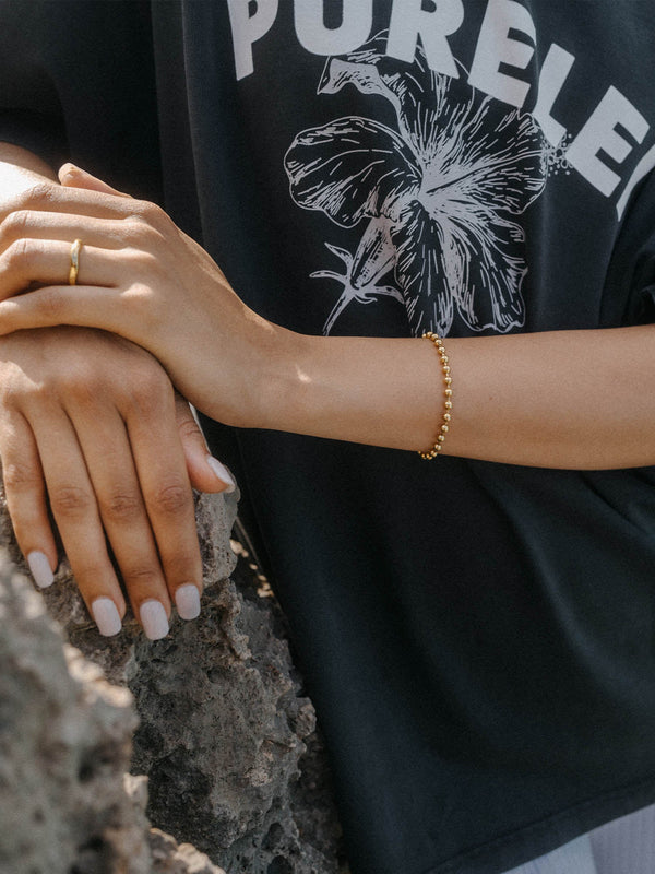 Roségoldenes Armband von PURELEI, zart und elegant, getragen auf einer Hand mit neutralem Nagellack.