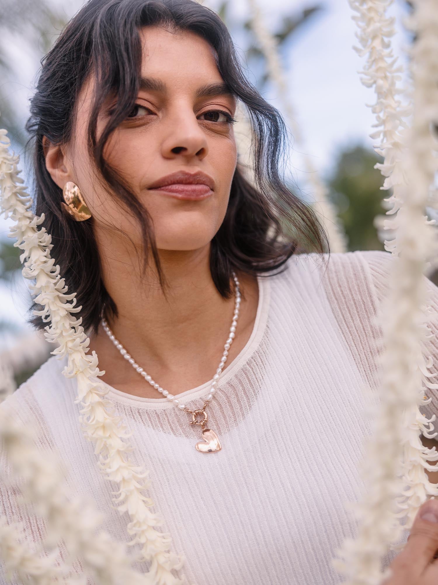 Perlenkette mit Herz-Anhänger, getragen von einer Frau, PURELEI inspiriert.